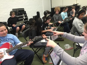 Emily helps Hudson perform the guitar track on her composition as he records it into Soundtrap.